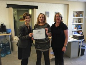 Stacey Bruzzese, President/CEO(left) and Melissa Seavey (right) present the Business of the Month Award to Angela Orben, Secretary of the Board of Directors for the Steve Lyons Fund organization.