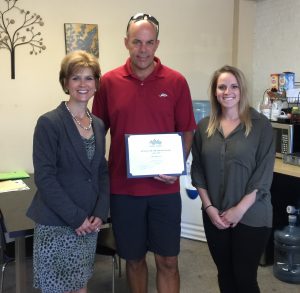 Chamber President, Stacey Bruzzese (left) and Membership Coordinator, Kelly Michal (right) present the Business of the Month Award to company owner, Doug Hall (center)
